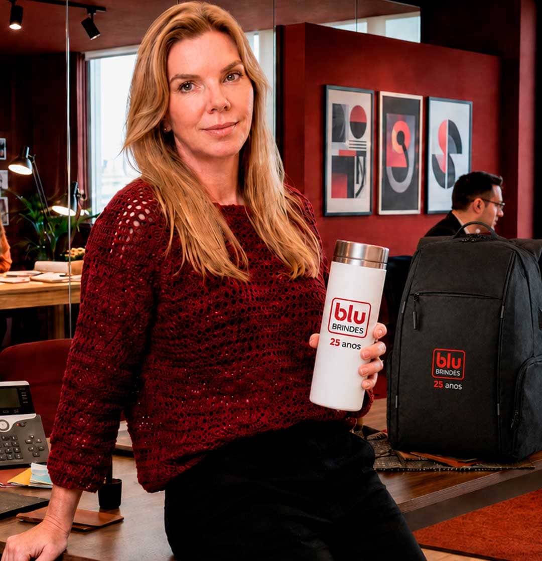 Daniela, dona da Blu Brindes, segurando uma garrafa personalizada